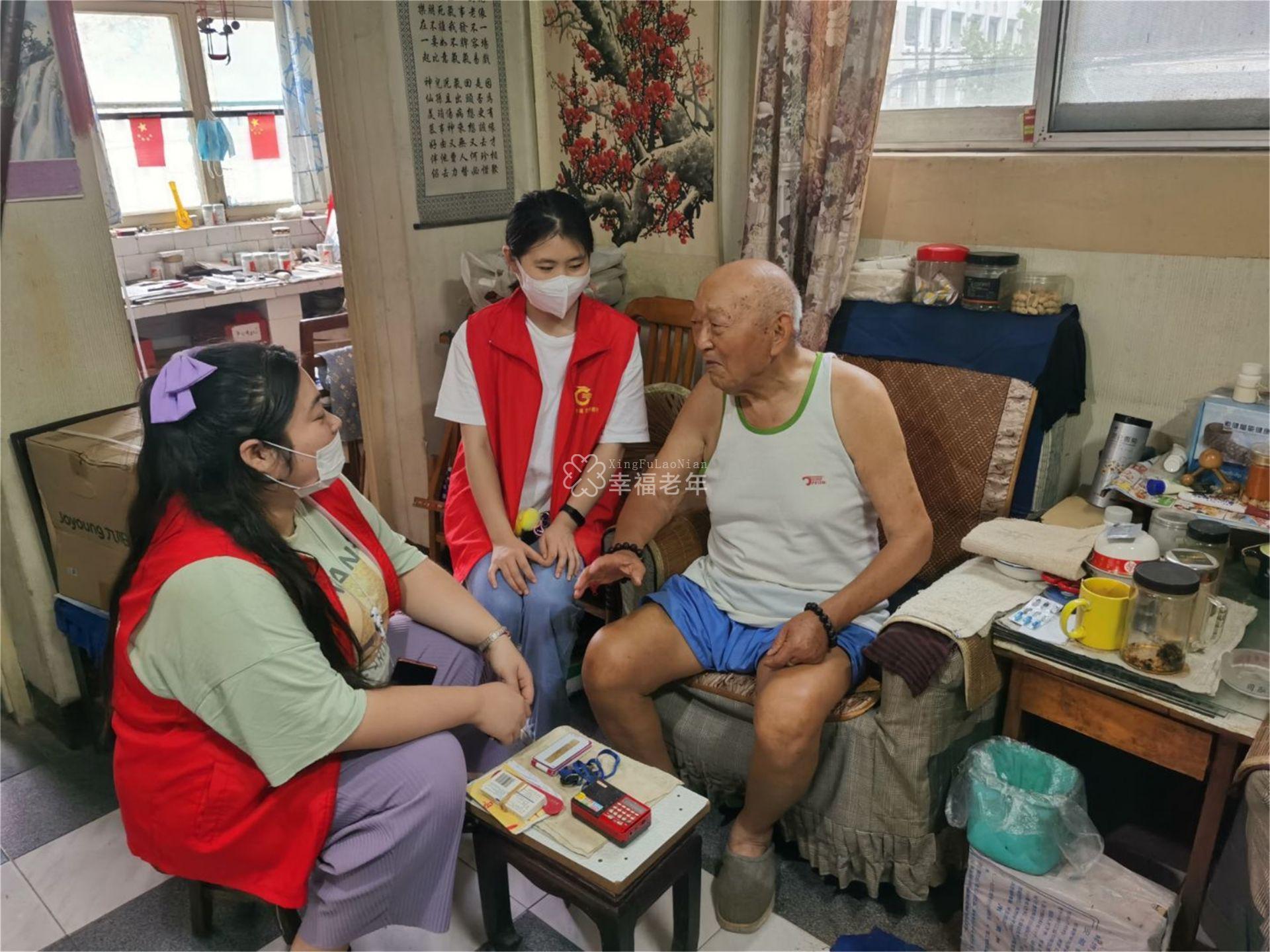 志愿者黄雅璇(左)在空巢老人家里与老人聊天