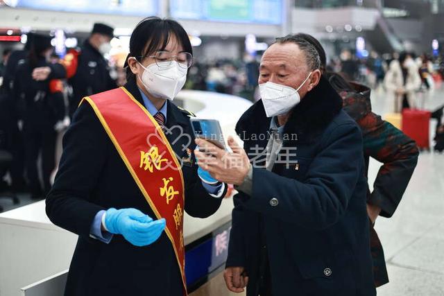 1月29日,重庆北站候车室,“银发服务队”工作人员为旅客提供咨询服务。苏志刚/摄