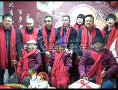 百岁老人集体庆寿，寿星佩戴红领巾，地方干部身后站